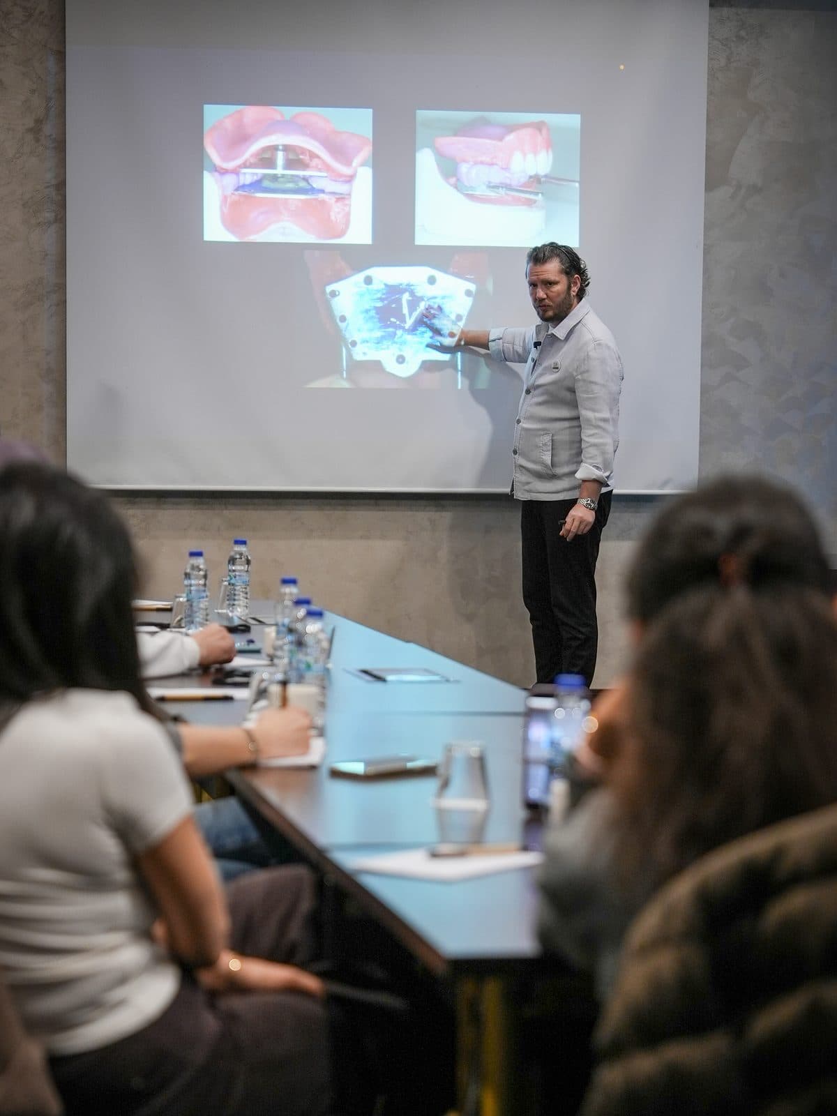 A lecture in front of the slides in the course hall